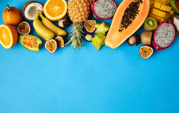 Diferentes frutas exóticas sobre fondo azul — Foto de Stock
