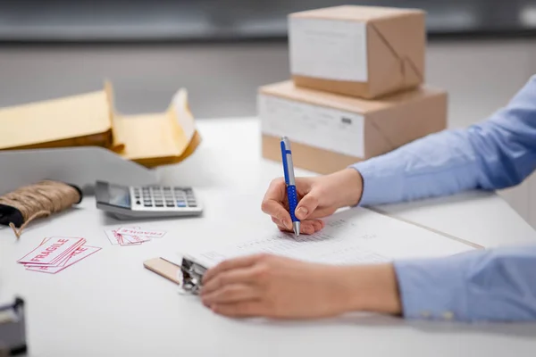 Hands with clipboard and parcels at post office — 스톡 사진