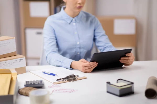 Femme avec tablette PC et presse-papiers au bureau de poste — Photo