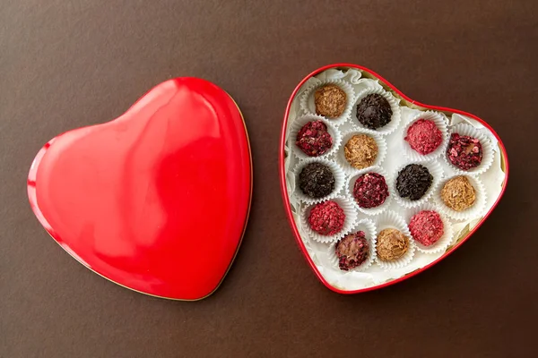 Caramelos en caja de chocolate en forma de corazón rojo —  Fotos de Stock