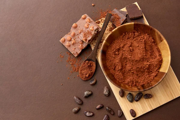 Chocolate with hazelnuts, cocoa beans and powder — Stock Photo, Image