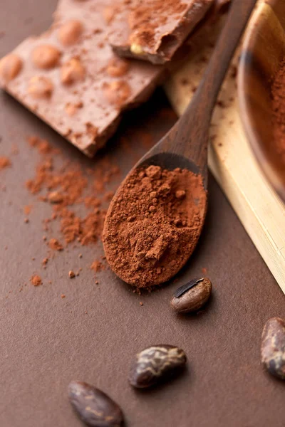 Bubuk coklat pada sendok kayu dengan cokelat — Stok Foto