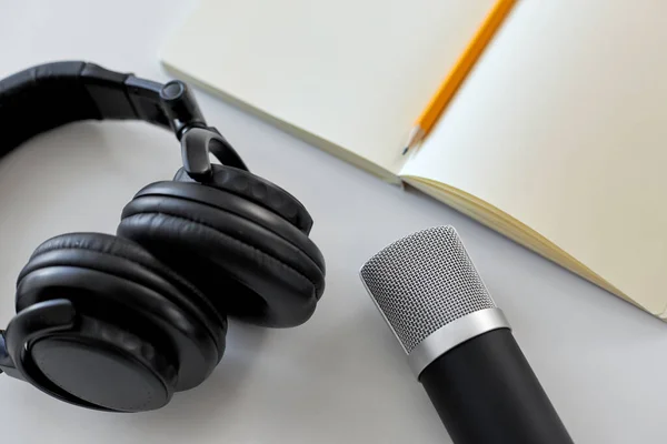 Headphones, microphone and notebook with pencil — Stok fotoğraf