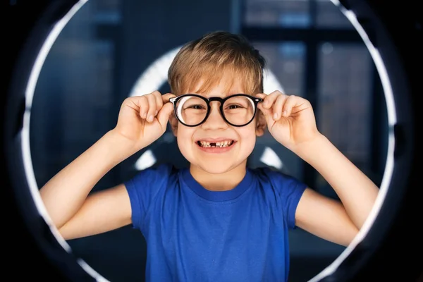 Boy in glasses over illumination in dark room — Stock Photo, Image