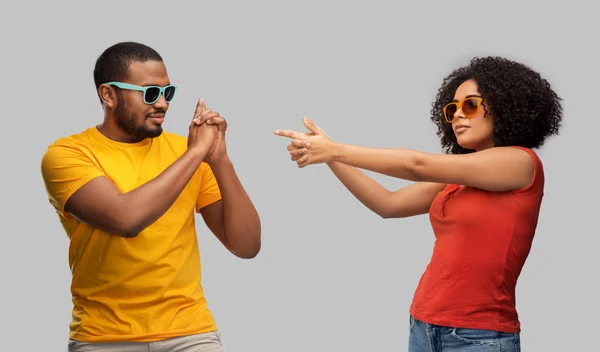African couple in sunglasses making gun gesture — Stock Photo, Image