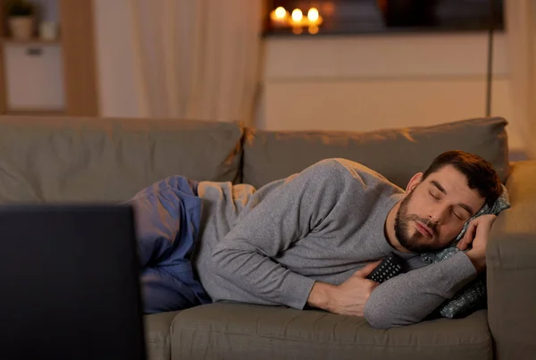 Hombre durmiendo en sofá con control remoto de televisión en casa —  Fotos de Stock