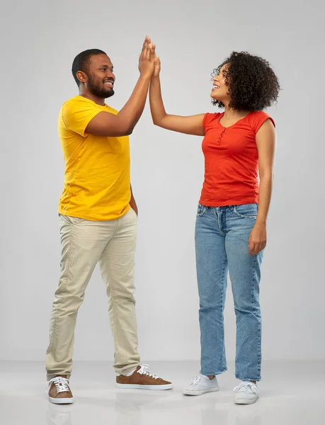 Feliz casal afro-americano fazendo alta cinco Fotos De Bancos De Imagens