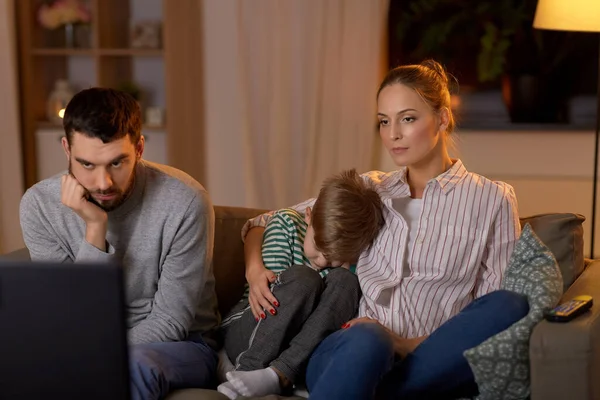 Familia viendo algo aburrido en la televisión por la noche —  Fotos de Stock