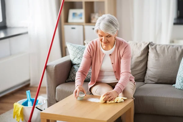 Idős nő takarítás asztal szódával otthon — Stock Fotó