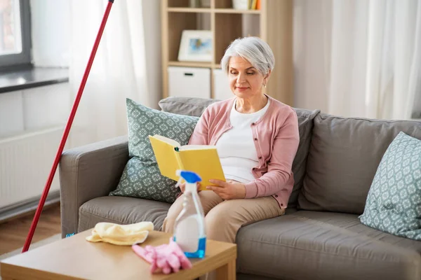 Libro di lettura donna anziana dopo la pulizia della casa — Foto Stock