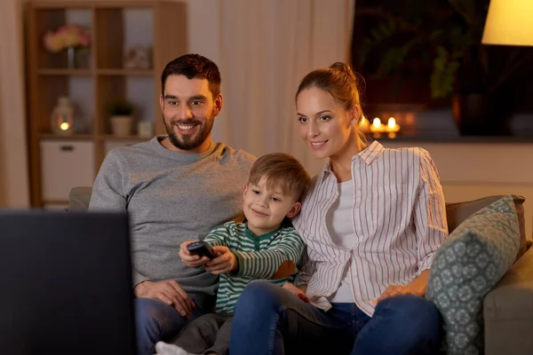Família feliz assistindo tv em casa à noite Imagem De Stock