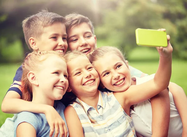 Szczęśliwe dzieci lub przyjaciół, biorąc selfie w lato park — Zdjęcie stockowe