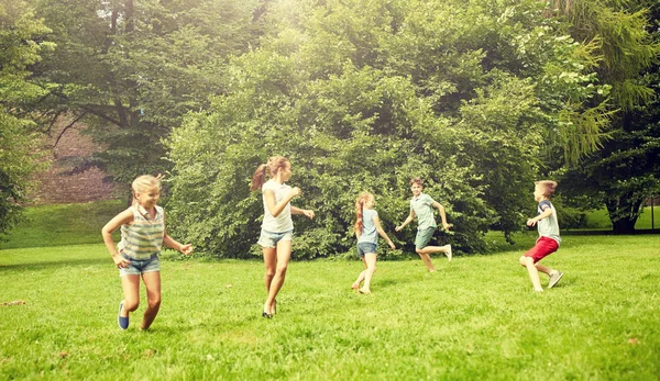 Niños felices corriendo y jugando al aire libre — Foto de Stock
