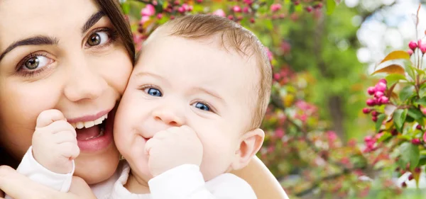 Mãe com bebê sobre o fundo do jardim primavera — Fotografia de Stock