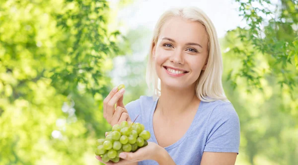 Donna felice mangiare uva — Foto Stock