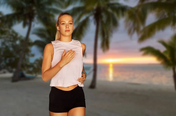 Happy young woman running along tropical beach — Zdjęcie stockowe