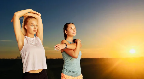 Vrouwen met fitness trackers die zich buiten uitstrekken — Stockfoto