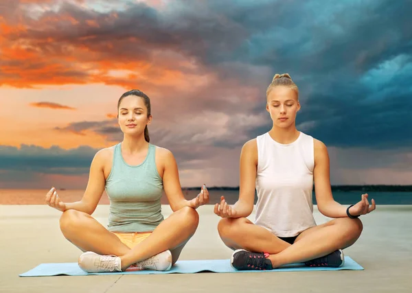 Mulheres fazendo ioga e meditando em pose de lótus — Fotografia de Stock