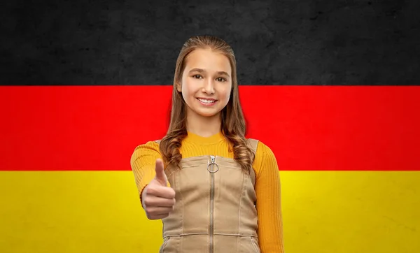 Teenage girl showing thumbs up over german flag — 스톡 사진