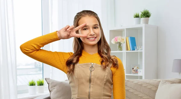 Sonriente adolescente mostrando la paz signo en casa —  Fotos de Stock