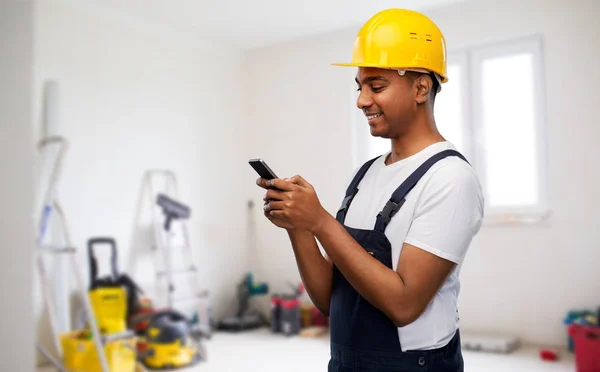 Happy indian or builder in helmet using smartphone — Stock Photo, Image