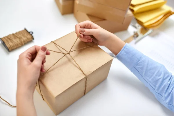 Händer packning paket och binda rep på postkontor — Stockfoto