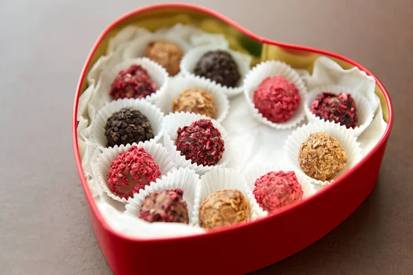 Bonbons in roter herzförmiger Schokoladenbox — Stockfoto