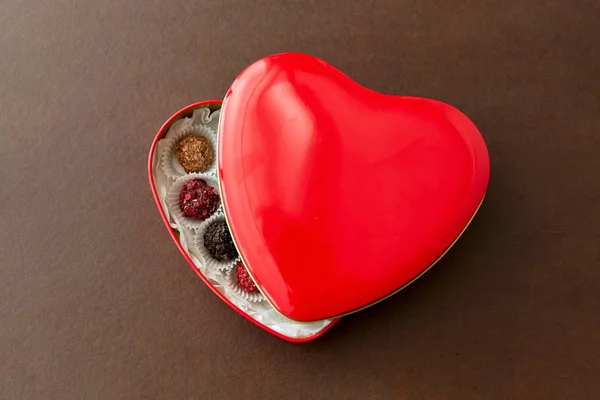 Godis i röd hjärtformad chokladask — Stockfoto