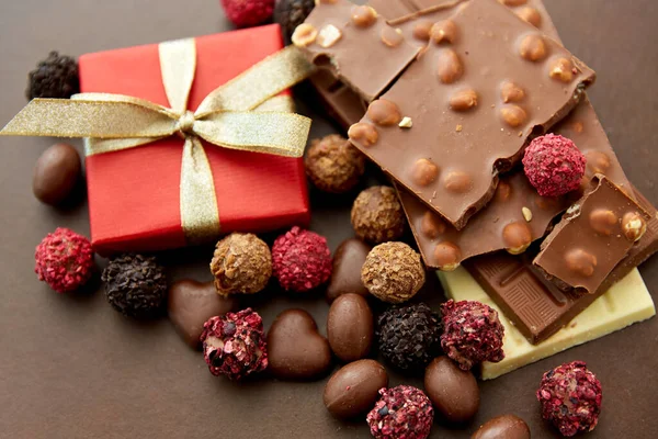 Zblízka různé čokolády, bonbóny a dárek — Stock fotografie