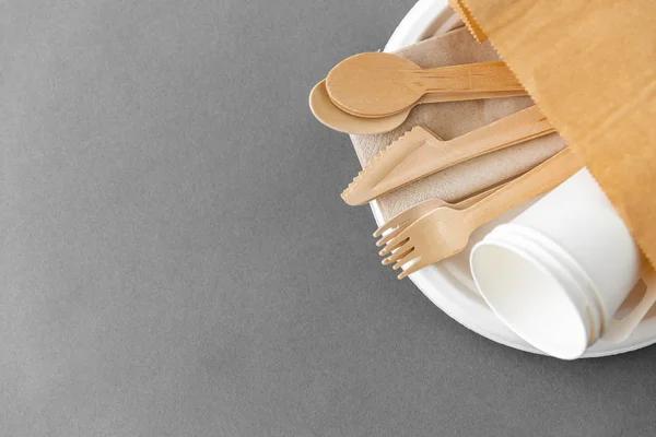 Wooden spoons, forks and knives on paper plate — Stock Photo, Image