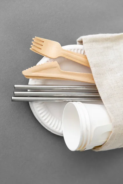 Wooden forks, knives and paper cups on plate — Stock Photo, Image