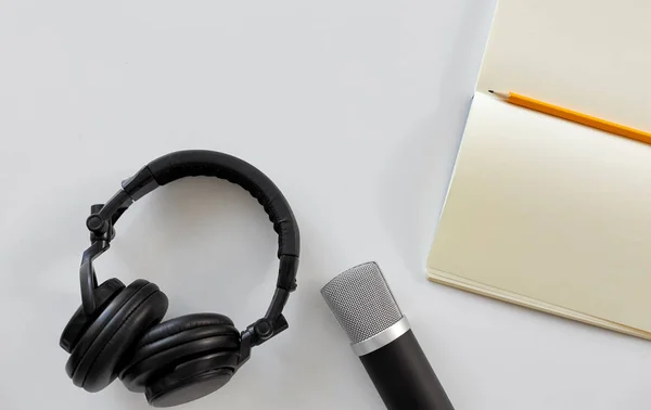Kopfhörer, Mikrofon und Notizbuch mit Bleistift — Stockfoto