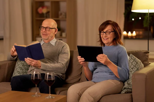 Couple aîné avec livre et tablette pc à la maison — Photo