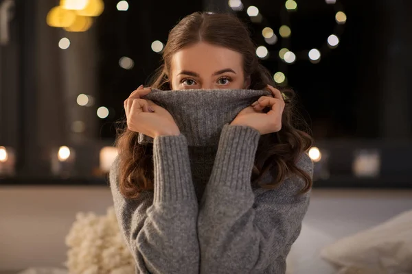 Jeune femme en pull en laine à la maison la nuit — Photo