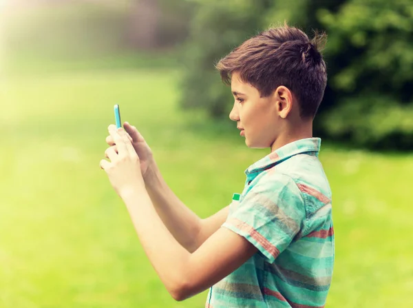 Jongen met smartphone speelspel in zomer park — Stockfoto