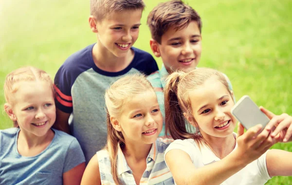 Niños felices o amigos tomando selfie en el parque de verano —  Fotos de Stock