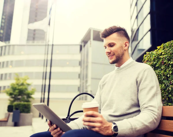 Uomo con tablet pc e caffè sulla panca stradale della città — Foto Stock