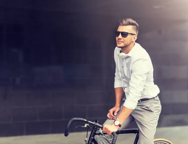 Hombre con bicicleta y auriculares en la calle de la ciudad — Foto de Stock