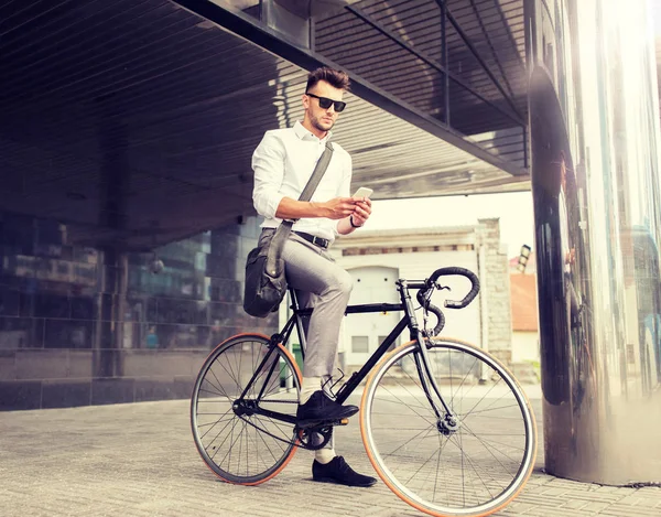 Hombre con bicicleta y teléfono inteligente en la calle de la ciudad — Foto de Stock