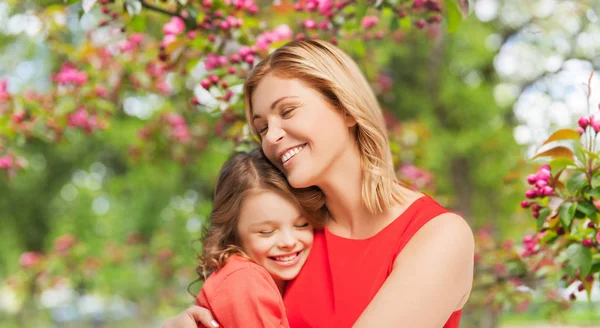 Happy mother and daughter hugging over garden — Stock Photo, Image