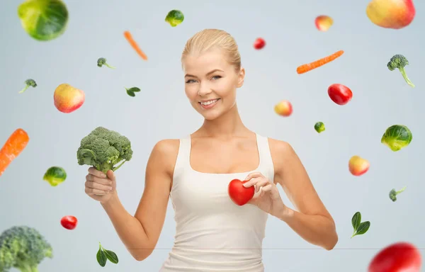 Heureuse jeune femme souriante avec coeur et brocoli — Photo