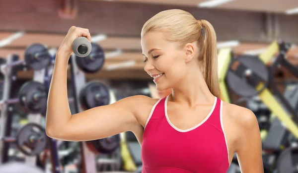 Glückliche junge Frau mit Hanteln beim Training im Fitnessstudio — Stockfoto