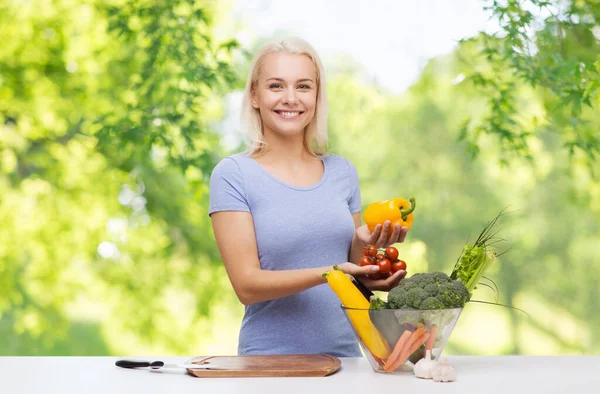 Sorridente giovane donna che cucina verdure — Foto Stock