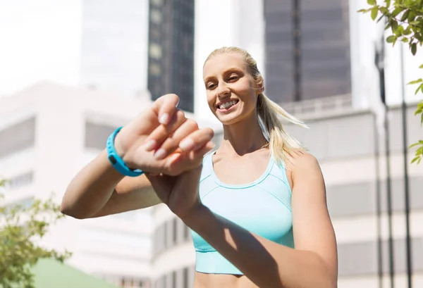 Femme heureuse avec tracker de fitness et écouteurs — Photo