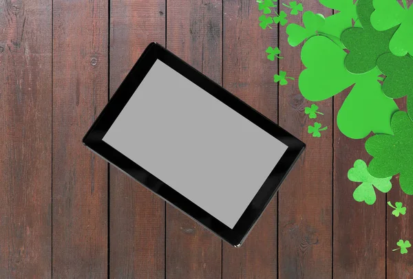 Tablet pc and st patricks day decorations on wood — Stock Photo, Image