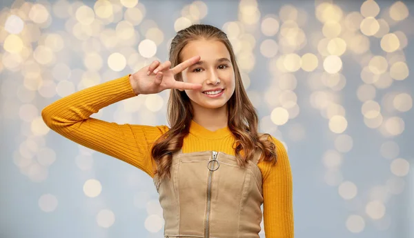 Smiling young teenage girl showing peace hand sign — Stock Photo, Image