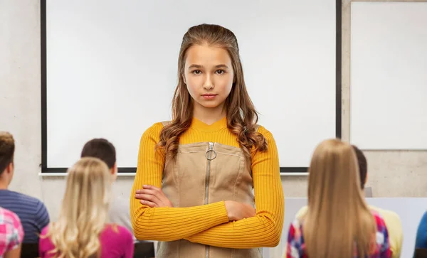 Seriös student flicka med korsade armar i skolan — Stockfoto