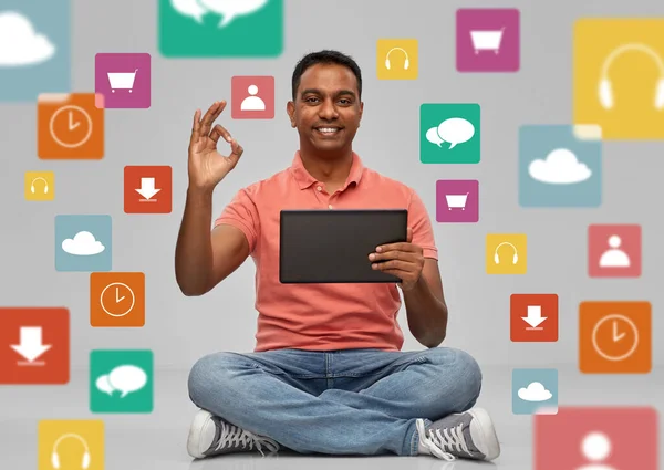 Ευτυχισμένος ινδός άνθρωπος με tablet pc πάνω από εικονίδια app — Φωτογραφία Αρχείου