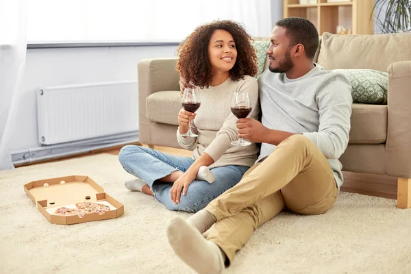 Szczęśliwa para z winem i pizzą na wynos w domu — Zdjęcie stockowe