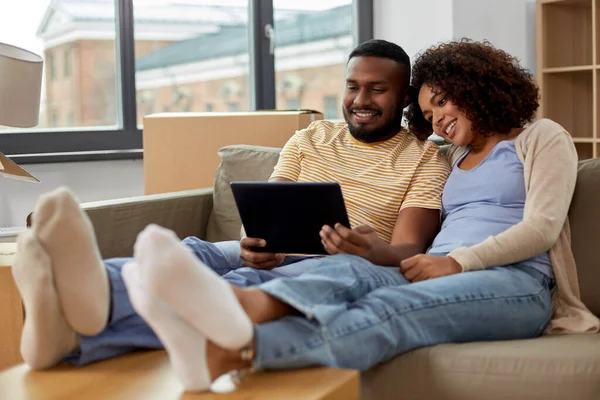 Feliz pareja con la computadora de la tableta PC en el nuevo hogar — Foto de Stock